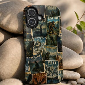May include: A black smartphone case featuring a collage of vintage-style national park posters depicting cryptids like Bigfoot, the Yeti, the Jersey Devil, and the Loch Ness Monster, with text labels for each creature and location printed on the surface.