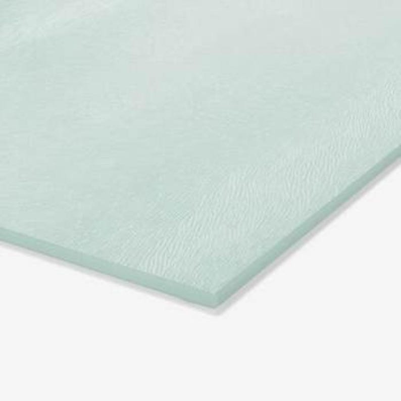 May include: A rectangular sheet of light mint green glass with a textured, rippled surface pattern. The glass has a smooth, straight edge and a semi-translucent appearance, showing a consistent pale green hue across the entire flat surface.