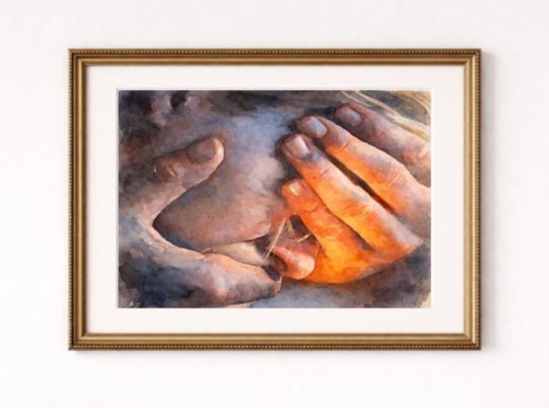 May include: Watercolor painting of hands cradling a face, framed in a gold-colored frame. The artwork features warm tones of orange and brown, with soft, diffused lighting. The hands are the focal point, with detailed brushstrokes.