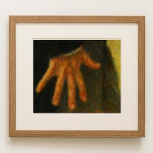 May include: A framed artwork depicting a detailed, orange-toned hand reaching out. The hand is the focal point against a dark background, with a light-colored area on the right. The artwork is encased in a light brown wooden frame.