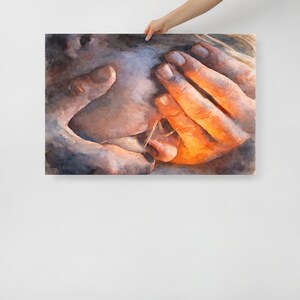 May include: A watercolor painting on canvas depicts a close-up of hands gently cradling a face. The artwork features warm orange and yellow tones on the hands, contrasting with the cooler blues and grays of the face, creating a soft, intimate feel.