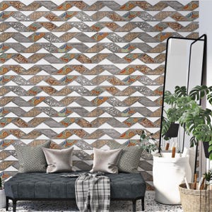 Peut inclure: Un mur avec un motif géométrique répétitif dans les tons marron, gris, blanc et orange. Le motif est une série de zigzags avec des éléments floraux et tourbillonnants décoratifs. Un banc gris foncé avec des coussins et une couverture est devant le mur.