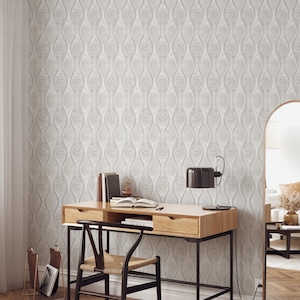 May include: A light gray, textured wallpaper with a repeating, vertical, organic pattern. A wooden desk with a black metal frame, a black desk lamp, and a woven chair are in front of the wallpaper. Books and a magazine rack are also visible.