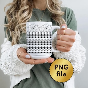 May include: A white ceramic mug featuring a black line art design with a top section of wildflowers and lower sections of repeating geometric patterns including arrows, circles, and horizontal lines. The mug has a curved handle and a smooth finish.