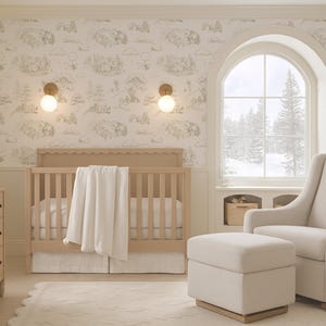 May include: A neutral-toned nursery featuring a wooden cot, changing unit, and a rocking chair with an ottoman. The room has patterned wallpaper and a large window with a view of a snowy scene. The room is decorated in a light, airy style.