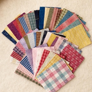 May include: A collection of square fabric swatches arranged in a fan shape. The pieces feature a variety of patterns including gingham, plaid, stripes, and solid colors in shades of blue, red, yellow, green, pink, and purple with textured finishes.