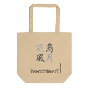 May include: Beige tote bag with a Japanese calligraphy design in gray and black. The bag features the text "To know nature is to know yourself." and the Japanese translation. The bag has a rectangular shape with two handles.