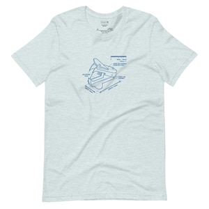 May include: A light heather grey short-sleeve t-shirt featuring a blue technical blueprint graphic of a staple remover. The print includes labels such as "Upper Jaw Assembly" and "Length 110mm," with a scale bar showing 0mm to 100mm.