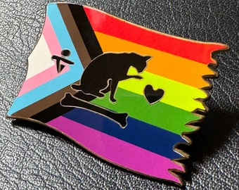 May include: A rainbow pride flag pin with a black cat silhouette, a bone, and a heart. The flag features the colors of the transgender, intersex, and pride flags.