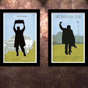 Op de afbeelding: Twee filmposterprints in zwarte frames. De linker poster is voor de film "Say Anything" en toont een silhouet van John Cusack die een ghettoblaster vasthoudt. De rechter poster is voor de film "The Breakfast Club" en toont een silhouet van een persoon die zijn vuist in de lucht steekt.