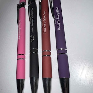 May include: Four ballpoint pens in pink, black, burgundy, and purple. Each pen has a silver clip and tip. The pink pen reads "Abso-Fucking-Lutely Not." The black pen reads "It's Fine. Everything is FUCKING Fine." The burgundy pen reads "I Know How to Fucking Count." The purple pen reads "Who Said This Was a Good Idea?"