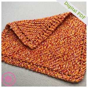 May include: A knitted dishcloth in a red, orange and white colour scheme. The dishcloth is folded in half and has a crocheted border.