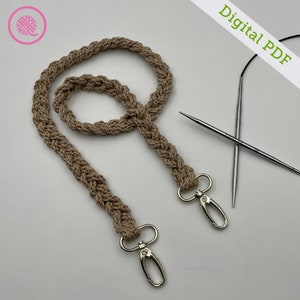 Könnte beinhalten: Ein beigefarbenes gehäkeltes Lanyard mit zwei silbernen Drehverschlüssen. Das Lanyard ist mit einem geflochtenen Stich gearbeitet und etwa 76 cm lang. Digitales PDF.
