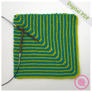 May include: A knitting project with green and blue yarn, showing a square pattern with a diagonal stripe design. The project is on knitting needles and the yarn is wound around a ball of yarn.