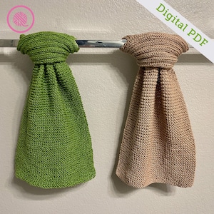 May include: Two knitted dishcloths hanging on a towel rail. One is green and the other is brown.