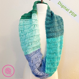 May include: A multi-colored knitted infinity scarf with a green, teal, light blue, and purple color gradient. The scarf is displayed on a white mannequin. Digital PDF.