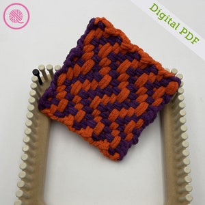 May include: A woven square coaster in orange and purple, made on a loom. The coaster is sitting on the loom, which is made of wood and has white pegs.