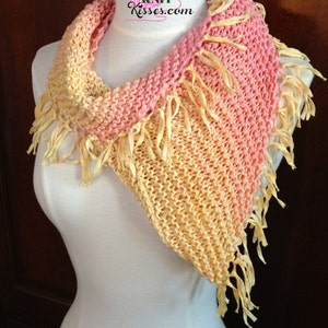 Könnte beinhalten: Ein gestrickter Schal mit einem Farbverlauf von Pink zu Gelb. Der Schal hat Fransen an den Rändern und wird auf einer weißen Schaufensterpuppe präsentiert. Der Schal trägt den Text "Good Knit Kisses.com".