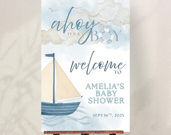 May include: A baby shower welcome sign with a nautical theme. The sign features a watercolor illustration of a sailboat, clouds, and the words "ahoy it's a boy" and "welcome to Amelia's Baby Shower".