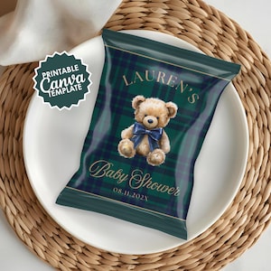 May include: A dark green and navy plaid baby shower favor bag with a teddy bear illustration and the text "LAUREN'S Baby Shower 08.11.202X". The bag is on a white plate and a woven placemat.