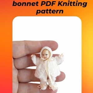 May include: A miniature doll wearing a white knitted jacket, pants, and bonnet set with thin ribbon ties. The text above reads: Miniature Baby Jacket, pants and bonnet PDF Knitting pattern. The doll has light skin and blonde hair.