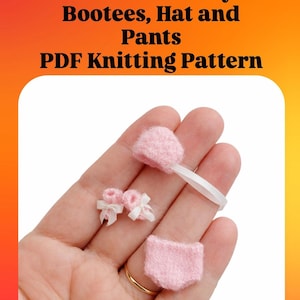 May include: Miniature baby clothing set in pink, including booties, a hat, and pants. The set is displayed on a hand. The image also includes the text "Miniature Baby Bootees, Hat and Pants PDF Knitting Pattern".