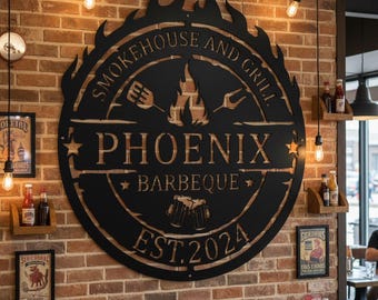May include: A large, black metal sign for "Smokehouse and Grill" with the name "Phoenix Barbeque" and "EST. 2024" cut out. The sign is circular with a flame design and is mounted on a brick wall.