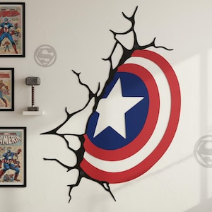 May include: A wall decoration featuring Captain America's shield, with a white star on a blue circle, surrounded by red and white stripes. The shield appears to be breaking through a wall, with black crack-like lines.