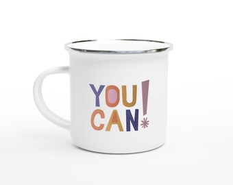 May include: White enamel mug with a silver rim and handle. The mug features the words "YOU CAN!" in colorful, playful lettering. The letters are in shades of blue, orange, pink, and purple. A cheerful and motivational design.