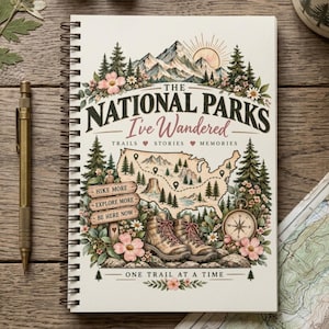 May include: A spiral-bound notebook with a cream cover featuring a colorful illustration of mountains, pine trees, a map of the USA, hiking boots, a compass, and flowers. The text reads: The National Parks I've Wandered, Trails, Stories, Memories, Hike More, Explore More, Be Here Now, One Trail At A Time.