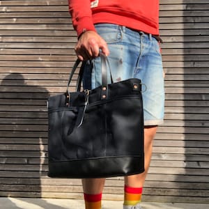 Schwarze Einkaufstasche aus gewachstem Canvas mit Lederboden und Cross-Body-Riemen