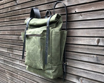 Olive green waxed canvas backpack with roll to close top and vegetable tanned leather shoulder straps