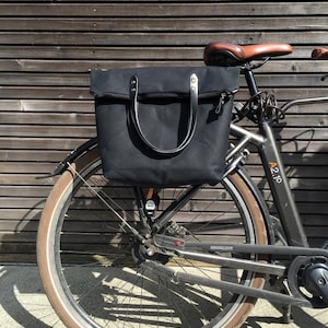 Zwarte fietstas van gewaxt canvas met ritssluiting en gekruiste riem