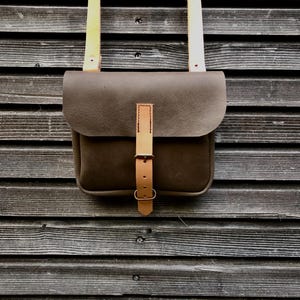 Bolso de mano, cartera realizada en piel engrasada color marrón grisáceo con bandolera regulable UNISEX