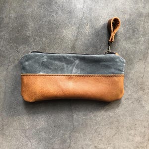 Estuche con cremallera y porta lápices realizado en lona encerada gris y piel engrasada color coñac