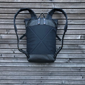 Black backpack medium size rucksack in waxed canvas, with leather front pocket and bottom image 2