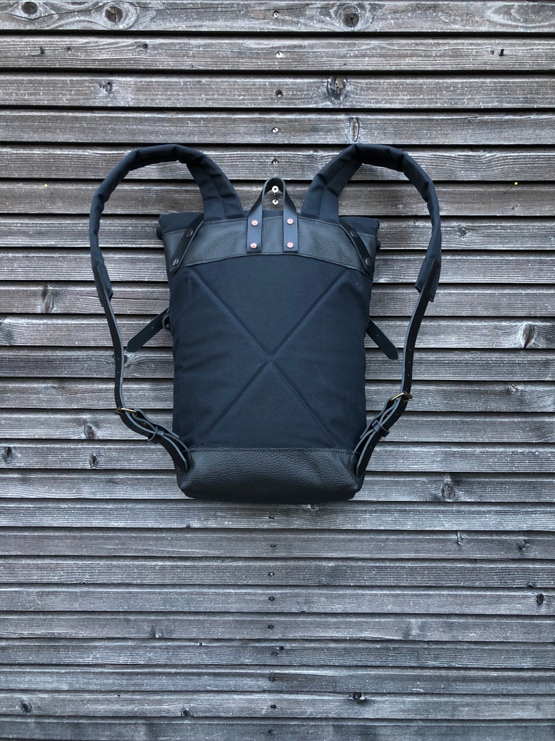 Black backpack medium size rucksack in waxed canvas, with leather front pocket and bottom image 2