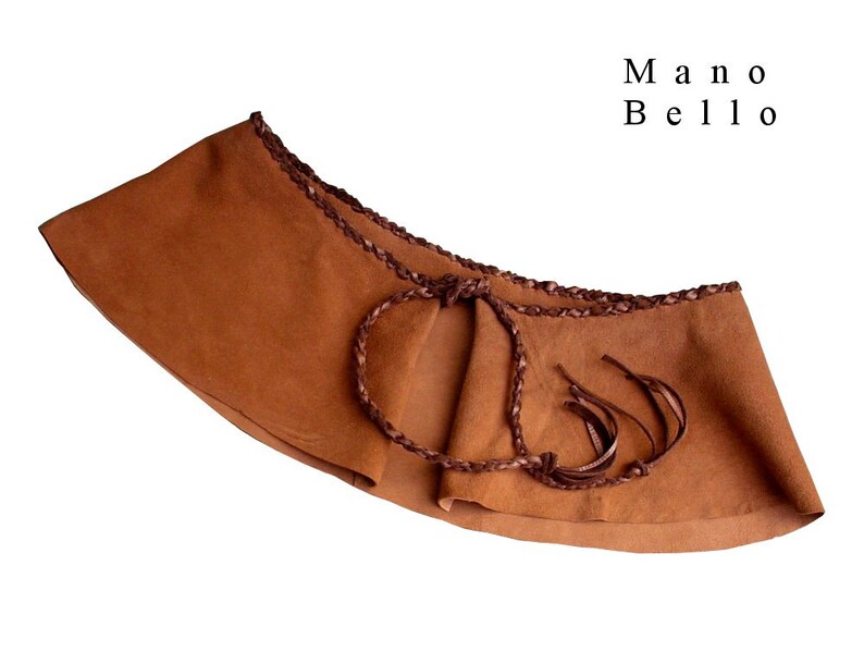 May include: A brown suede belt with a braided leather trim and fringe detail. The belt is tied in the front with a knot.
