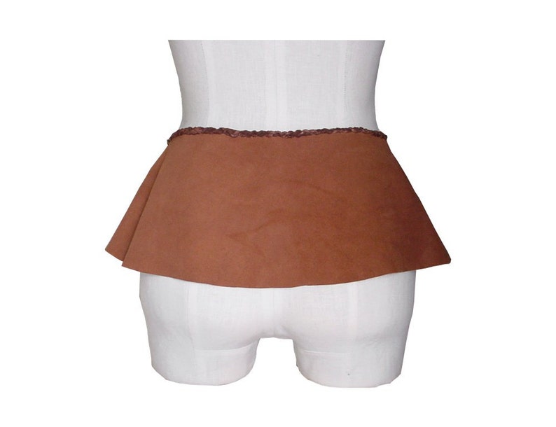May include: A brown suede skirt with a ruffled hem and a decorative trim around the waistband.