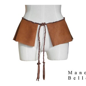 May include: A brown leather belt with a braided design and long tassels. The belt is tied around a white form and has two flaps of leather on either side.