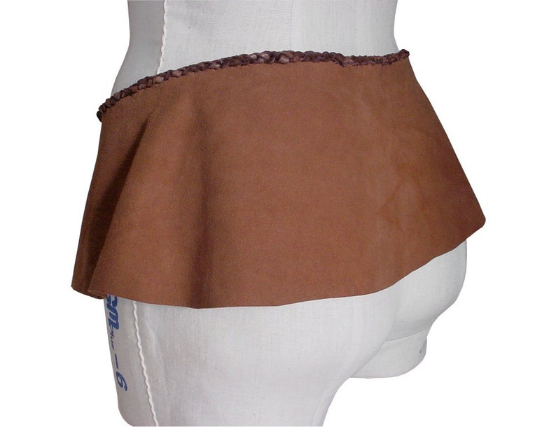 May include: A brown suede skirt with a braided leather waistband. The skirt is gathered at the waist and has a flared shape.