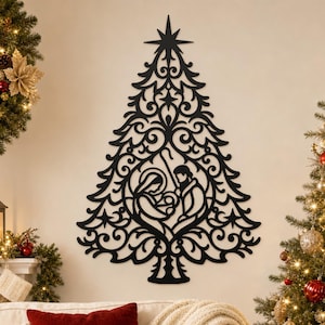 Peut inclure: Une décoration murale noire en forme de sapin de Noël avec des motifs de volutes complexes. Le centre présente une silhouette découpée d'une scène de nativité montrant deux personnages au-dessus d'un berceau, surmontée d'une grande étoile.