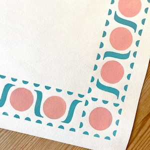 May include: A white background with a teal and pink border. The border is made up of a repeating pattern of circles and curved lines.