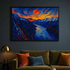 May include: A framed abstract landscape painting depicting a river winding through blue mountains under an orange and yellow sky. The artwork hangs above a green velvet sofa with orange, teal, and gold cushions.