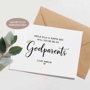 Puede incluir: Una tarjeta blanca con el texto "UNCLE ELLA & AUNTIE BEN WILL YOU BE BE MY Godparents LOVE AMELIA" en escritura negra. Un halo dorado está encima de la palabra "Godparents". Un sobre marrón está detrás de la tarjeta. La tarjeta también dice "CAN BE FULLY PERSONALISED".