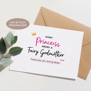 Puede incluir: Tarjeta de felicitación blanca con el texto "Every Princesss Needs a Fairy Godmother" en rosa y negro, con un gráfico de corona dorada. La tarjeta está junto a un sobre marrón y una ramita de hojas verdes. El texto "Thank you for being MINE" es visible.