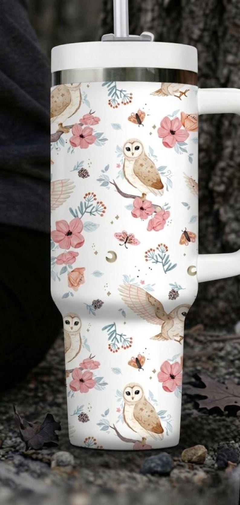 Puede incluir: Taza de viaje blanca con un dise&ntilde;o envolvente con b&uacute;hos, flores rosas y mariposas. La taza tiene un asa y una tapa blancas y es adecuada para bebidas fr&iacute;as o calientes. La taza mide aproximadamente 18 cm de alto.