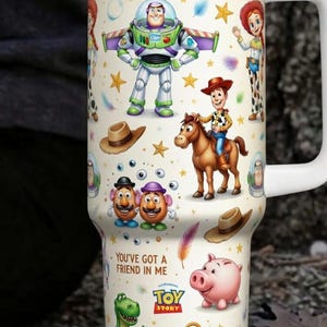 May include: A white travel mug featuring characters from the animated film "Toy Story." The design includes Buzz Lightyear, Woody, Jessie, and other characters, along with the phrases "To Infinity and Beyond" and "You've Got a Friend in Me."