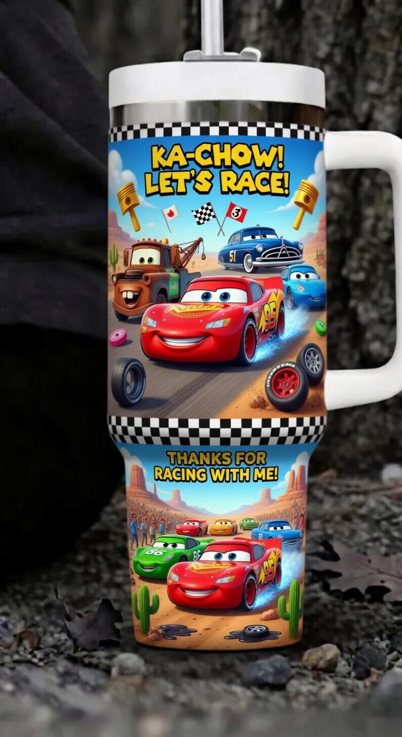 Puede incluir: Un termo blanco con un dise&ntilde;o de dibujos animados de coches de carreras y las frases "KA-CHOW! LET'S RACE!" y "THANKS FOR RACING WITH ME!". El termo tiene un asa grande y un patr&oacute;n de cuadros.