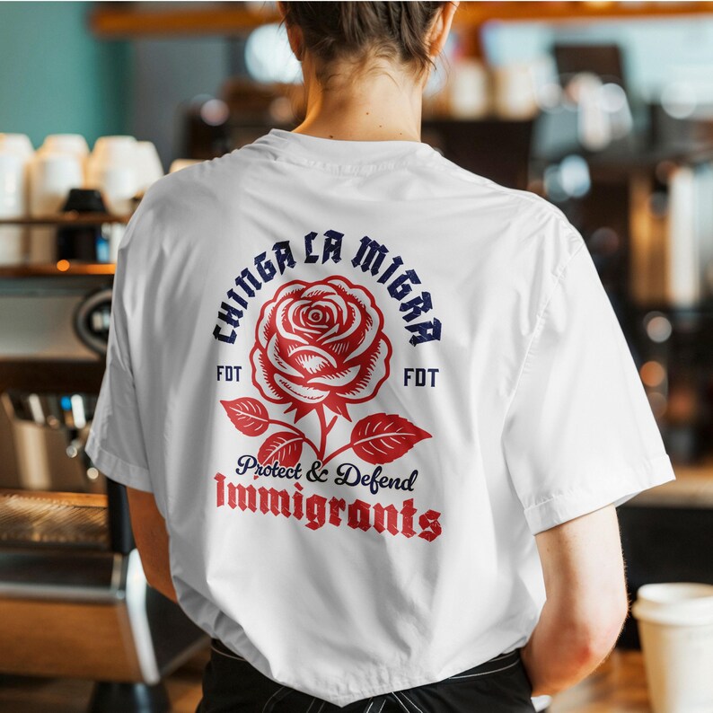 May include: White t-shirt with a red rose graphic and the text "Chinga La Migra" in blue, and "Protect & Defend Immigrants" in red. The shirt is a short-sleeved crew neck.